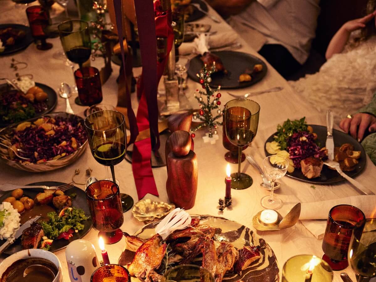 Slávnostná večera servírovaná na stole ozdobenom sviečkami a dizajnovými dekoráciami.