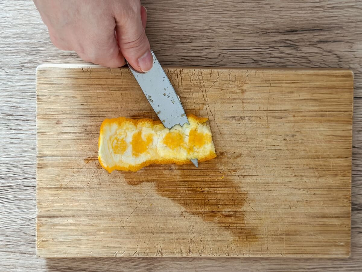 Čistenie vnútornej strany pomarančovej kože nožíkom.