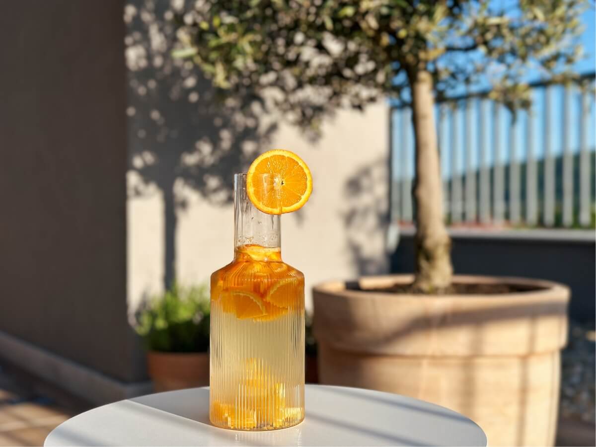 Pomarančová limonáda v sklenenej karafe.