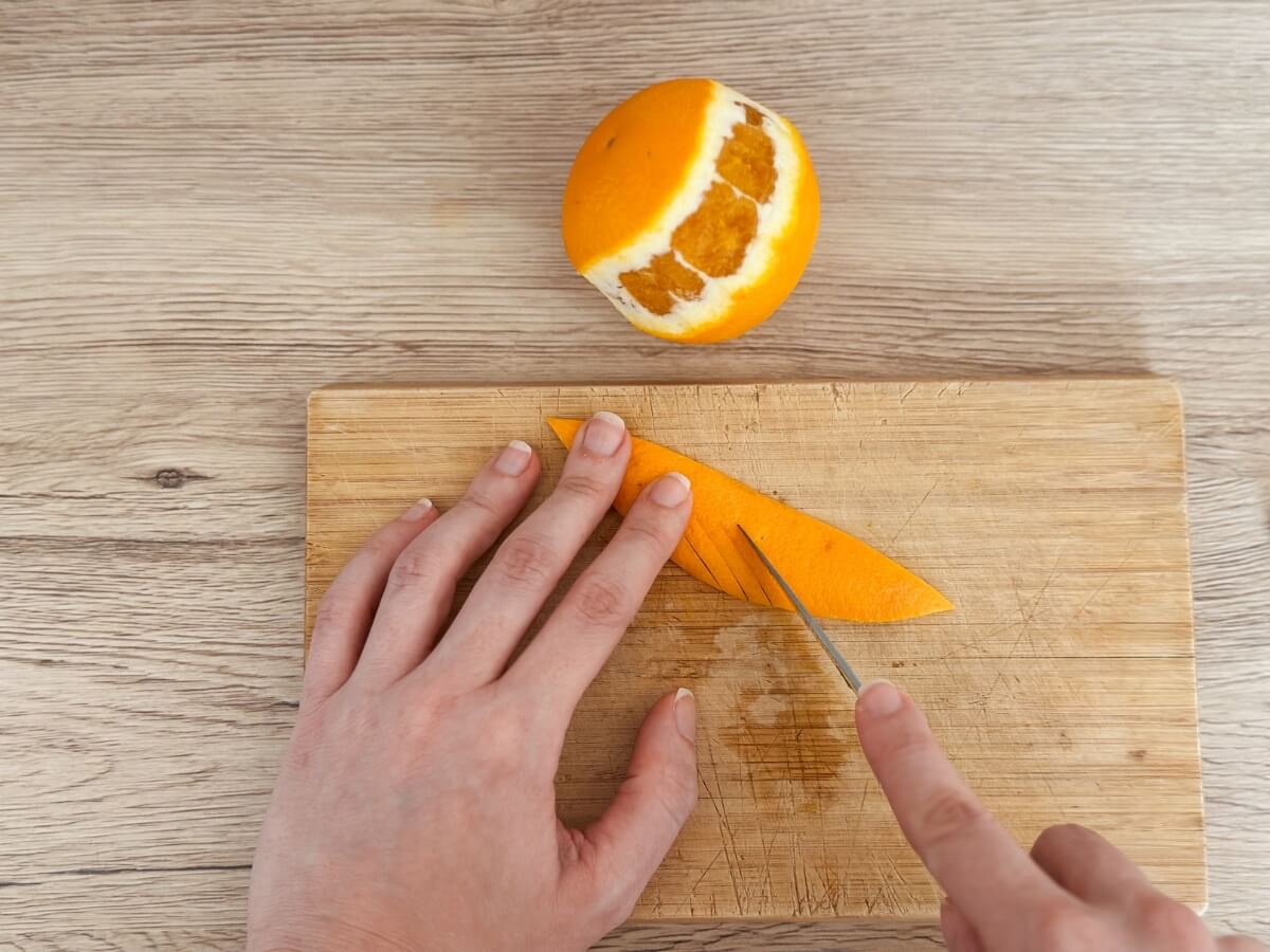 Rezanie pomarančovej kôry počas tvorenia pomarančovej špirály.