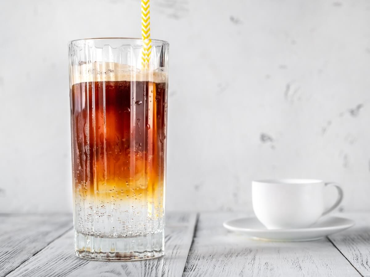Káva s tonikom Espresso Tonic vo vysokom sklenenom pohári so slamkou.
