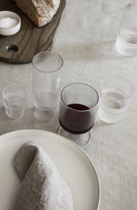 Malý vrúbkovaný pohárik na tvrdý alkohol na stole pri keramickom tanieri