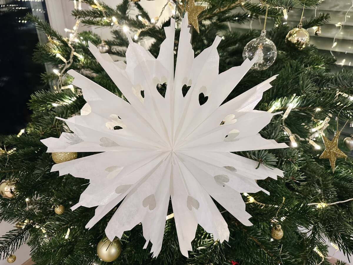 Papierová snehová vločka na vianočnom stromčeku.