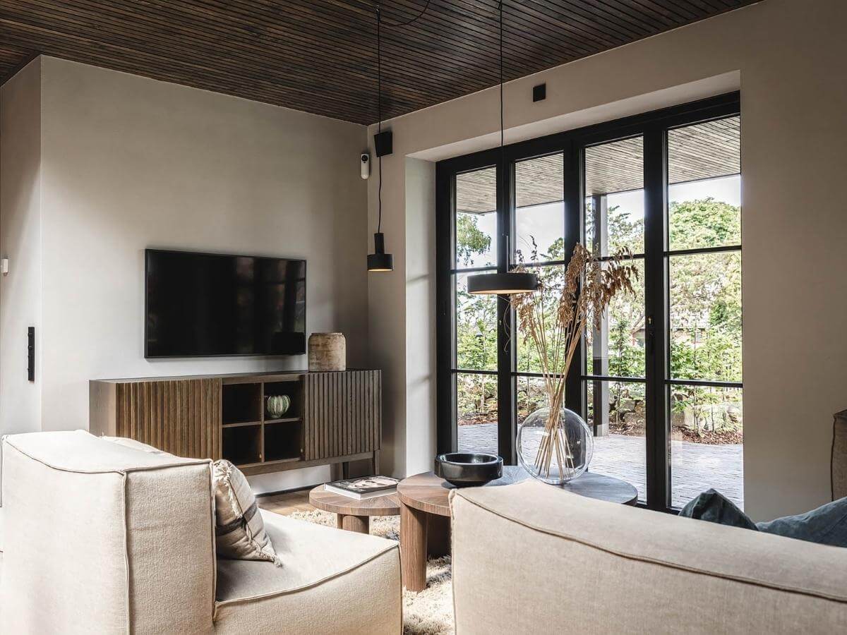 Moderná minimalistická obývačka s veľkým oknom s výhľadom do záhrady.