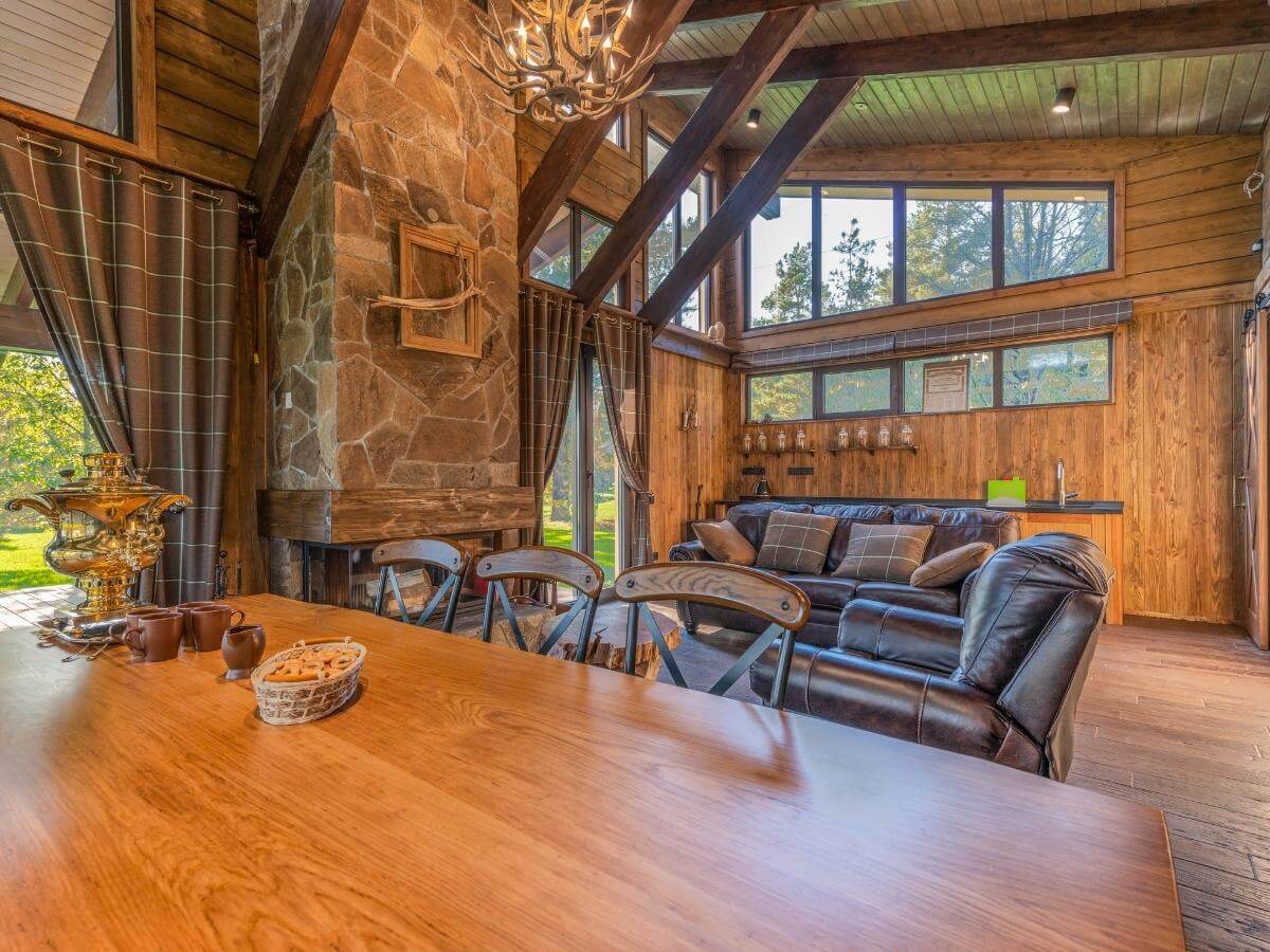 Obývačka s jedálňou v dome s priznanými drevenými trámami a zariadením v rustikálnom štýle.