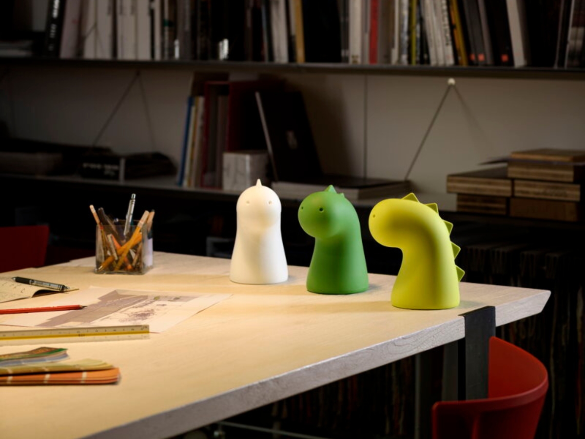 Dizajnoví draci v bielej, zelenej a žltozelenej farbe na stole v pracovni.