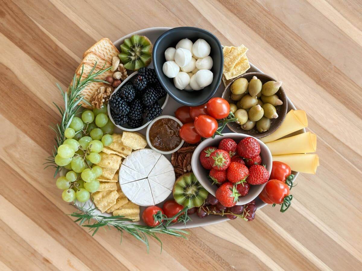 Syrová charcuterie board s ovocím a olivami.