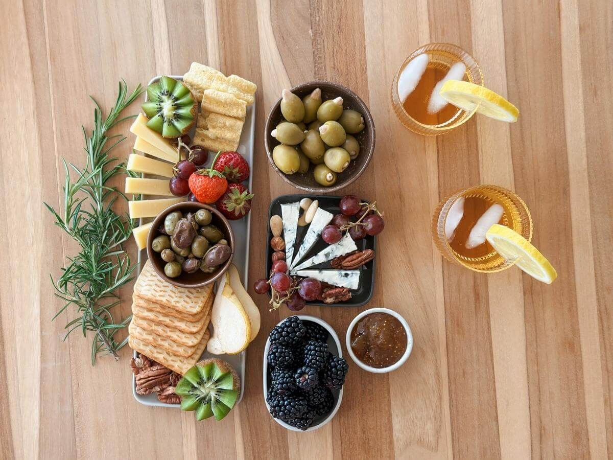 Malé obložené taniere s výberom syrov, ovocia, olív a krekrov.