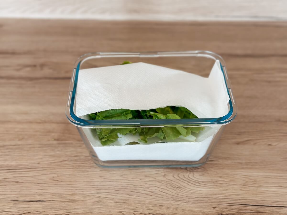 Papierová servítka položená na listovom šaláte v sklenenej nádobe.