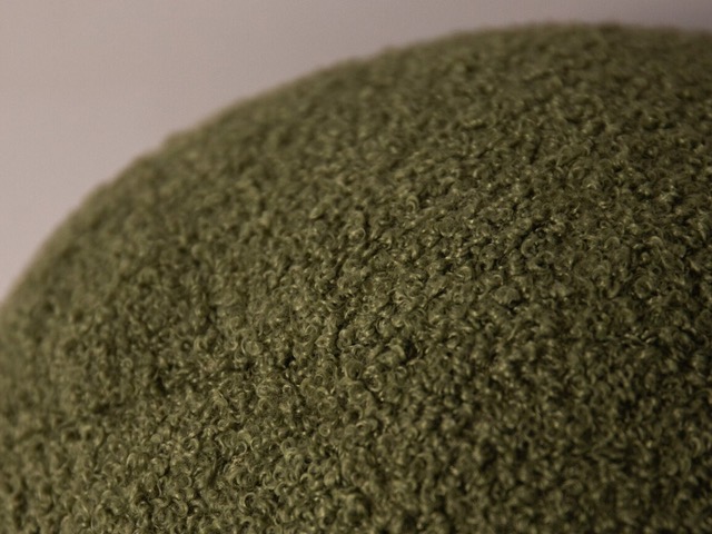 Detail modernej tkaniny bouclé v zelenej farbe.