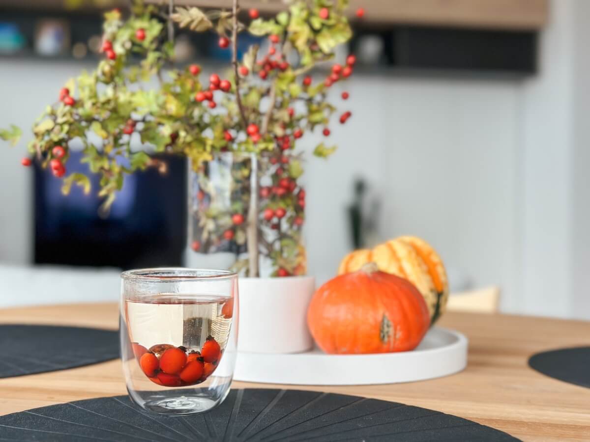 Šípkový čaj položený na stole s prírodnou jesennou výzdobou.