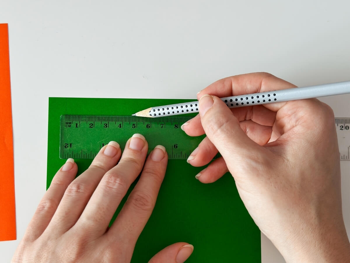 Meranie origami papiera pomocou pravítka a ceruzky.