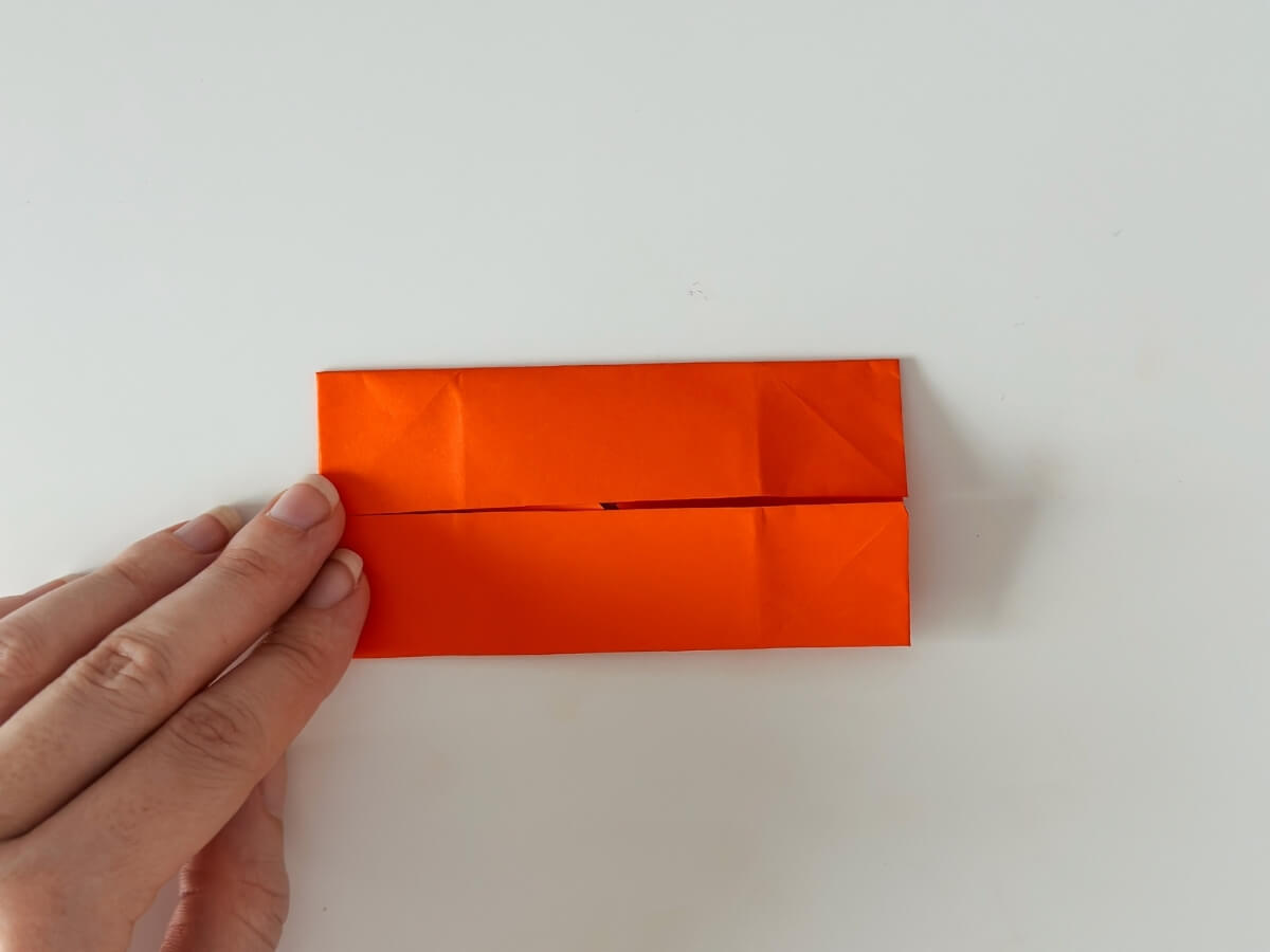 Zložený horný a spodný roh origami papiera.