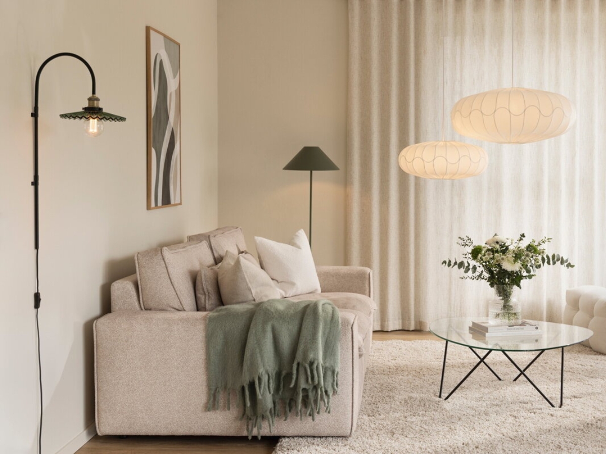 Presvetlená obývačka so stojanovým, nástenným a dvomi závesnými svietidlami.