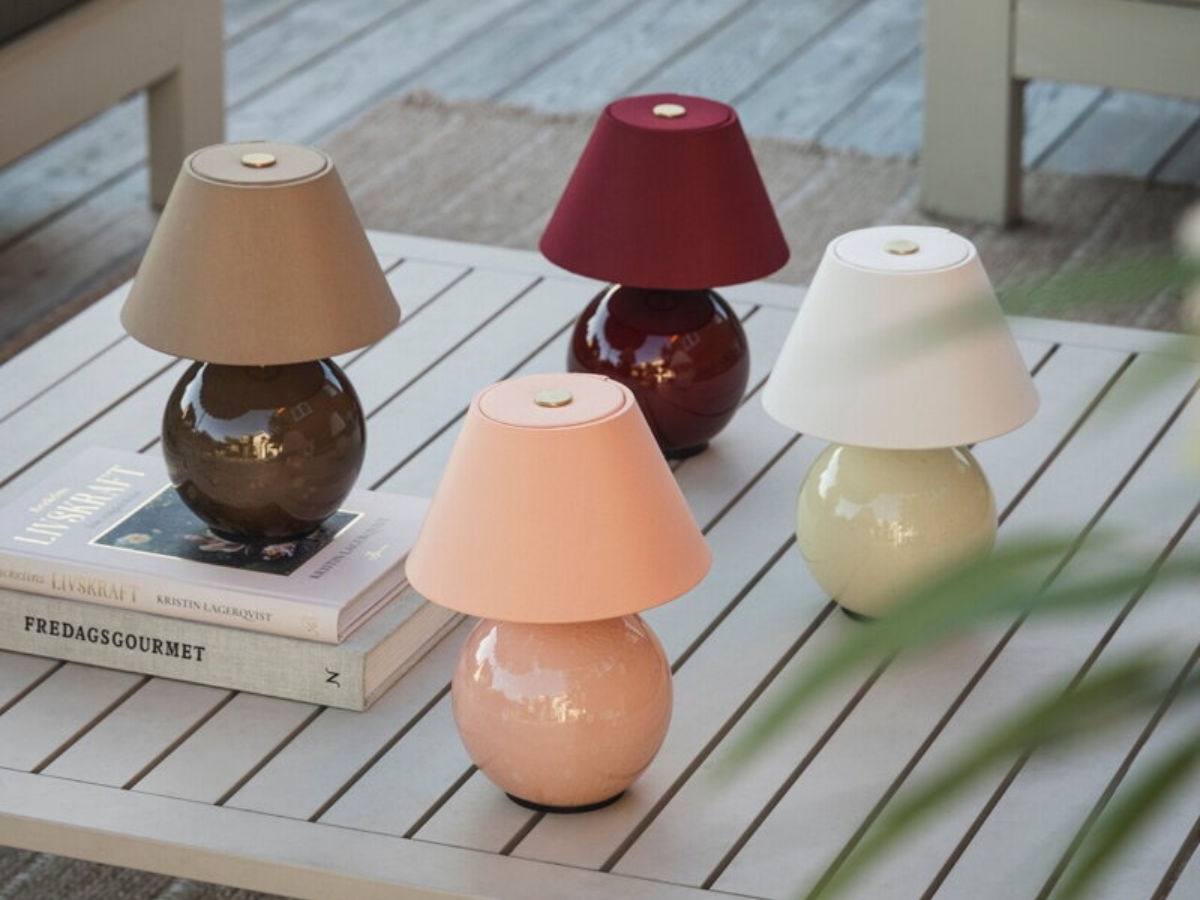 Prenosné stolové lampy v štyroch farebných prevedeniach na stole.