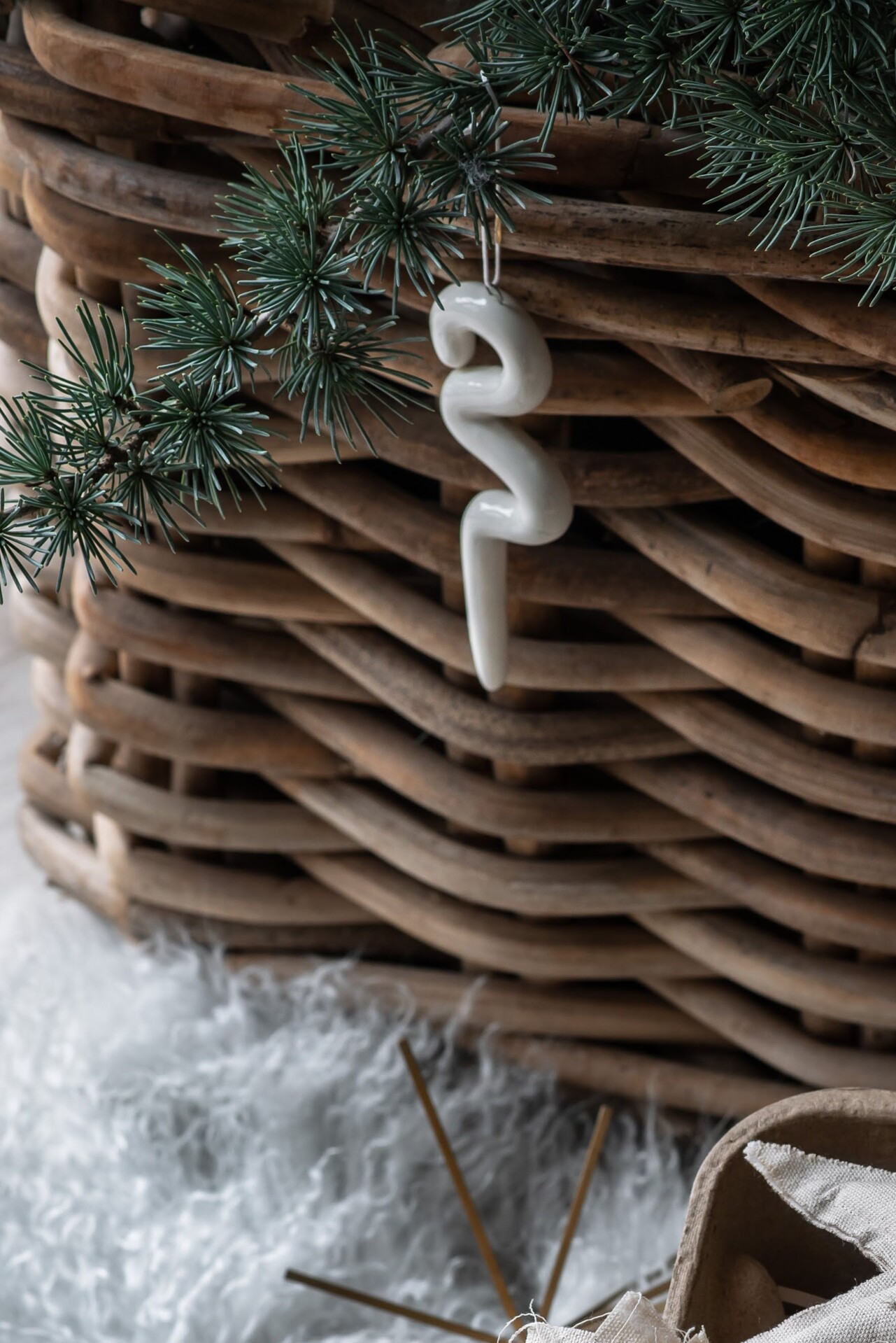 Keramická biela ozdoba v tvare kvapľa na vianočnom stromčeku.