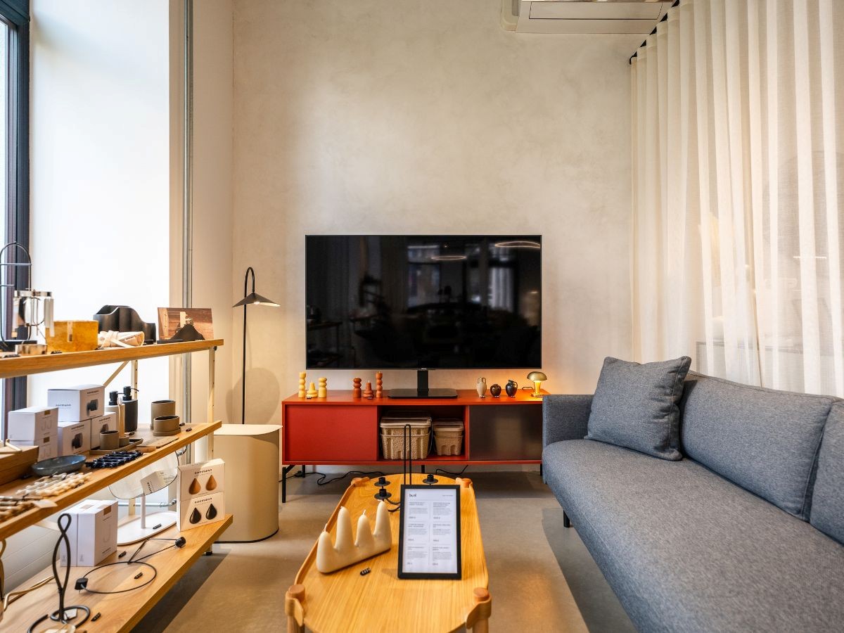 Obývacia zóna showroomu s elegantným TV stolíkom a pohodlnou pohovkou.