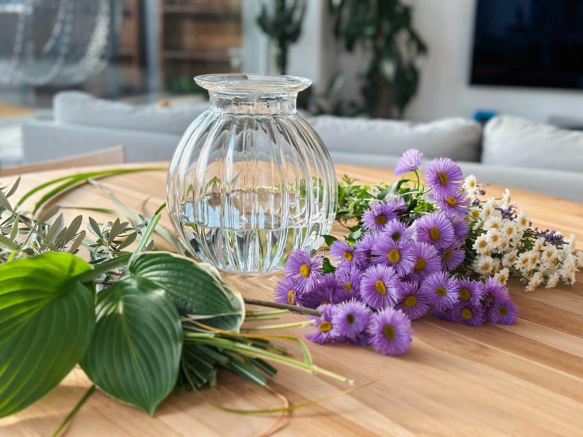 Váza naplnená vodou a kvety položené na stole.