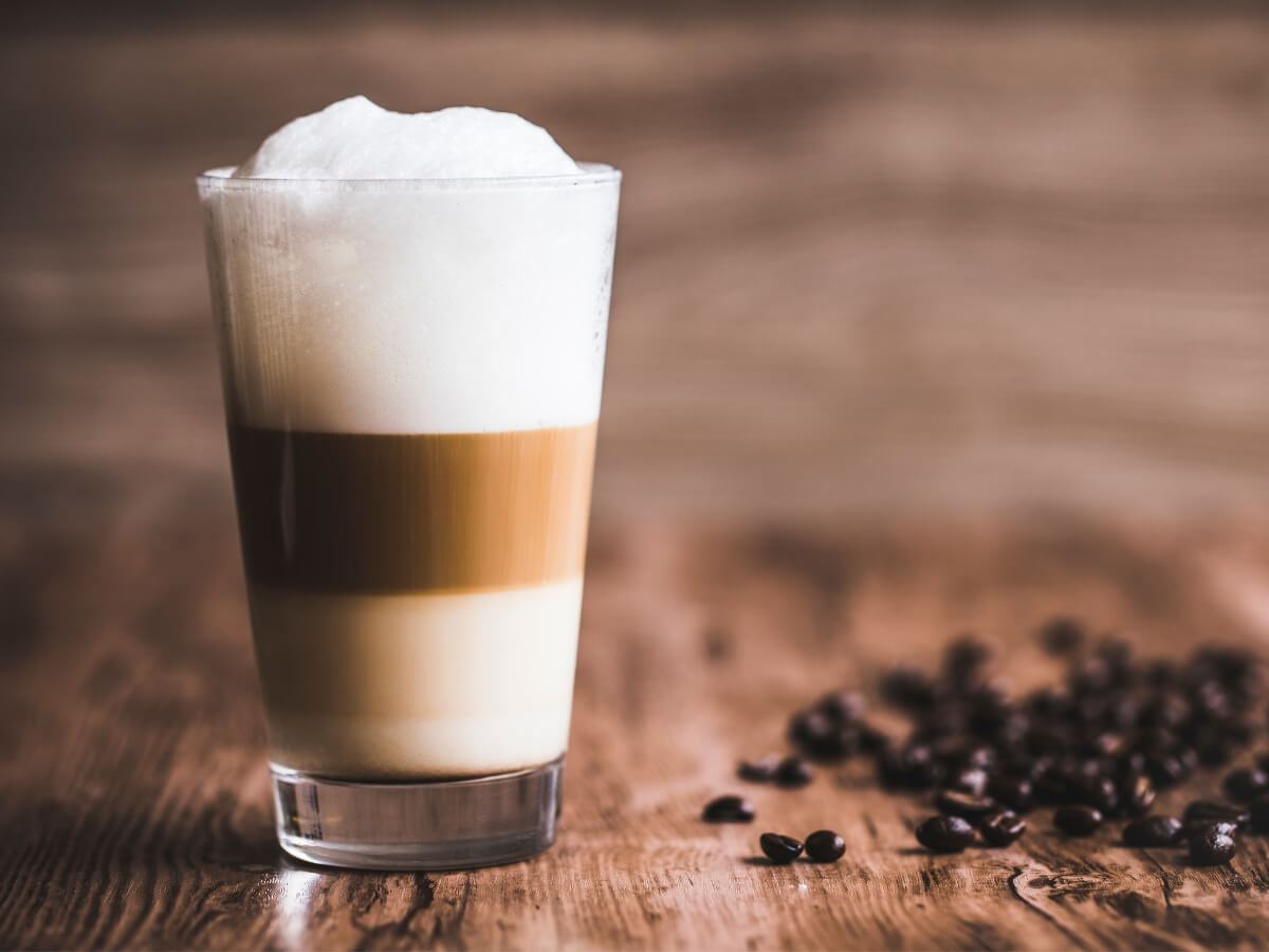 Káva Caffe Latte vo vysokom sklenenom pohári.