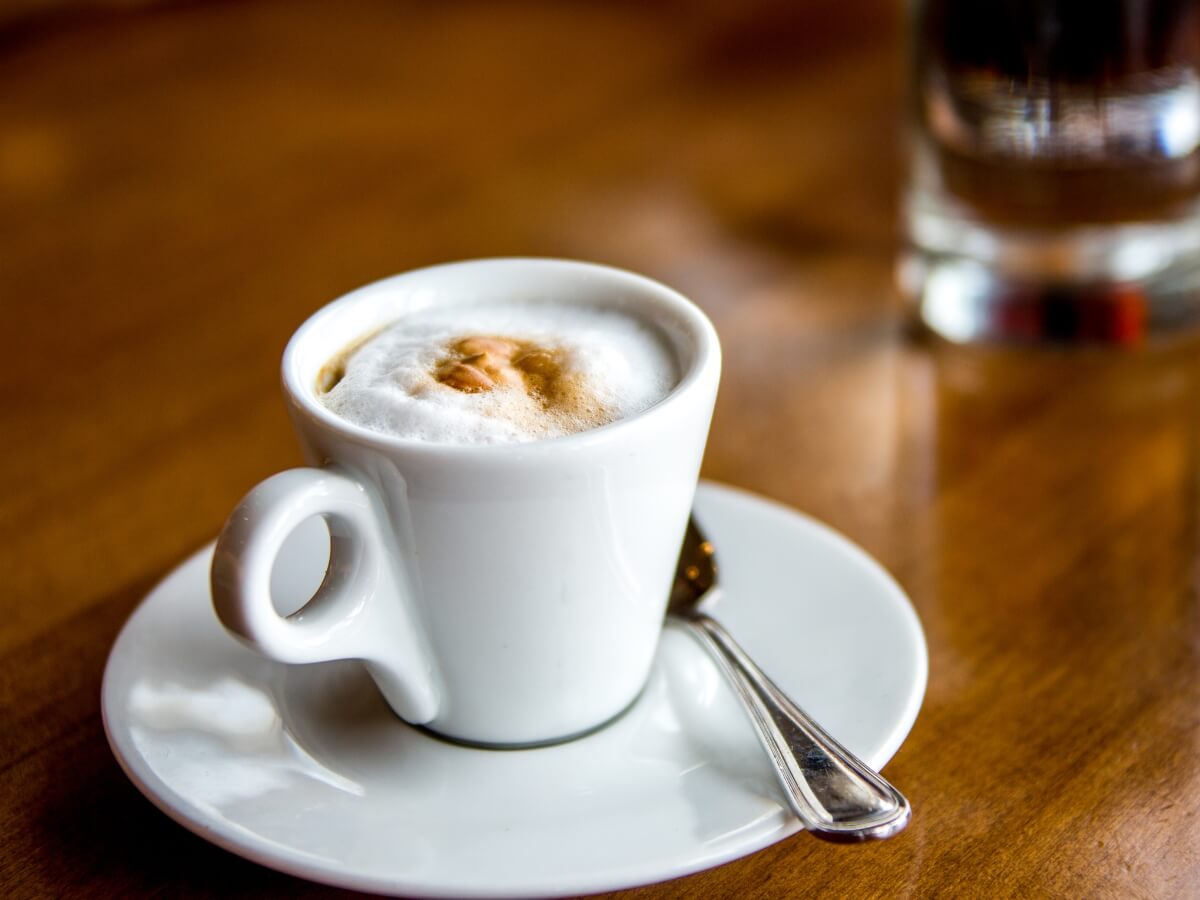 Káva Macchiato v malej bielej šálke.