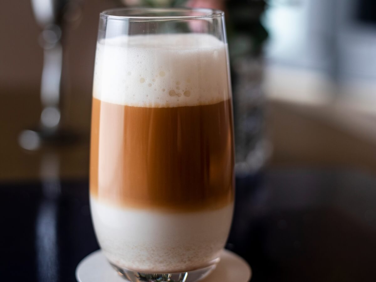 Káva veľké Macchiato v sklenenom pohári s mliekom a penou.