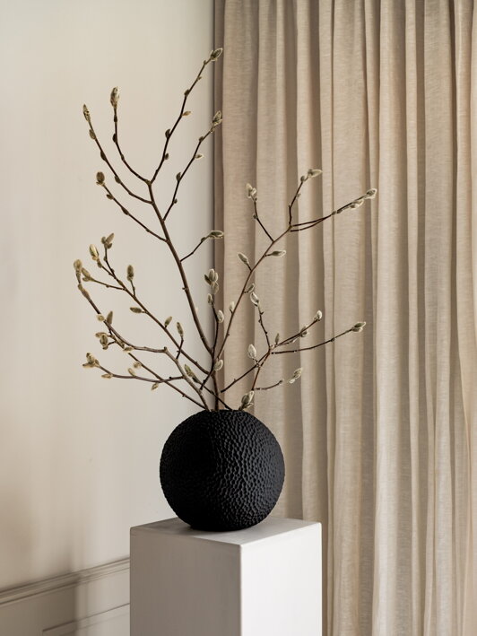 Veľká čierna keramická váza s vetvičkami v obývačke