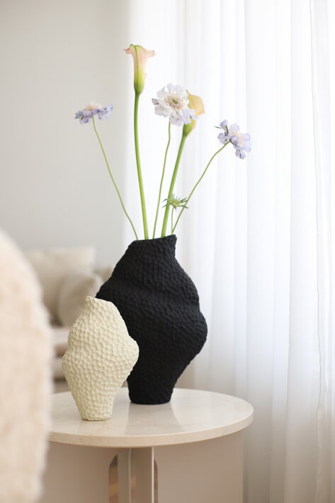 Malá nepravidelná váza z krémovej keramiky na stolíku v obývačke
