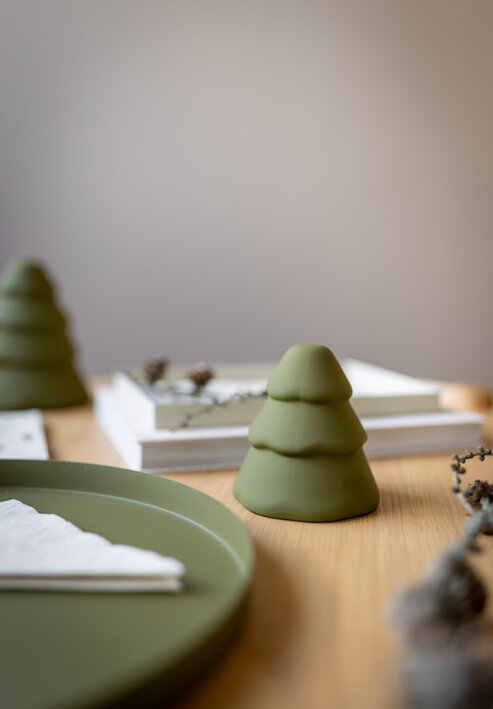Malý zelený stromček z keramiky na jedálenskom stole pri podnose