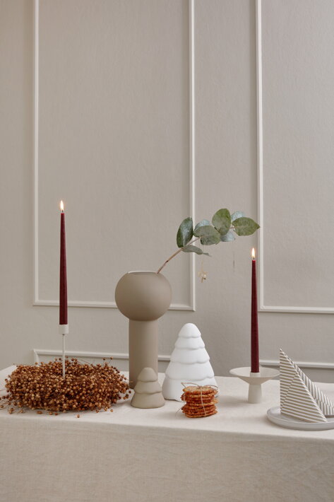 Veľký biely stromček z keramiky na slávnostnom jedálenskom stole so sviečkami