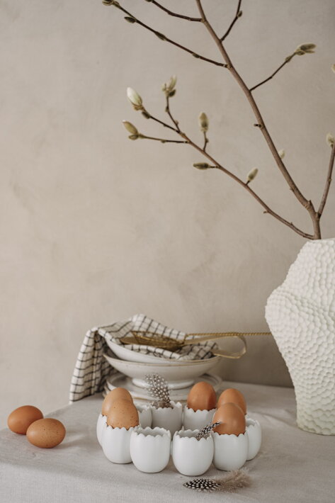 Dizajnová veľkonočná dekorácia z bielej keramiky v tvare venca zo škrupiniek naplnená vajíčkami