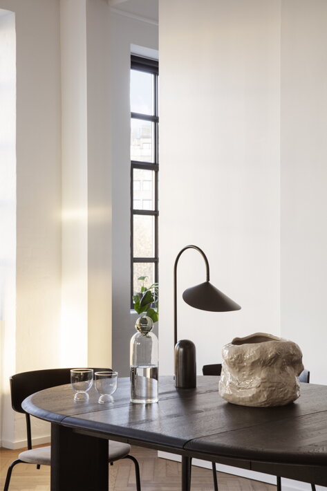 Luxusná čierna stolová lampa nad dizajnovou vázou na jedálenskom stole