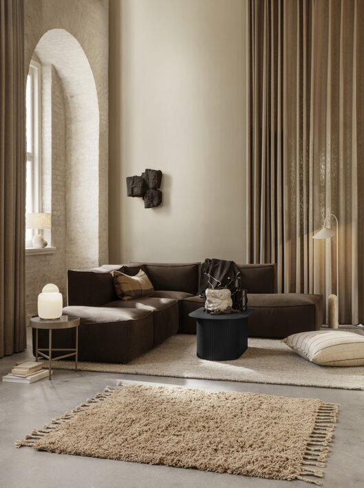 Luxusná stojanová lampa z kašmírového kovu nad dizajnovou pohovkou v obývačke