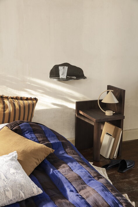 Prenosná kovová lampa v kašmírovej farbe na nočnom stolíku v štýlovej spálni