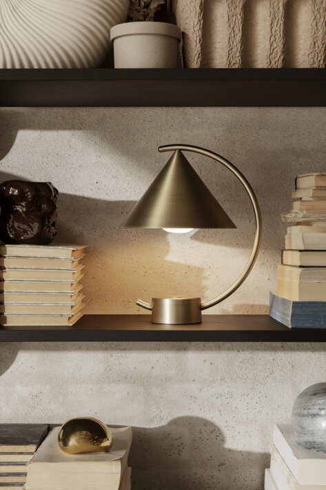 Mosadzná prenosná lampa s geometrickým dizajnom osvetluje domácu knižnicu