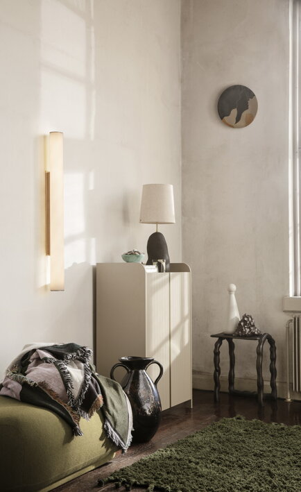 Veľká nástenná lampa z opálu a mosadze v dizajnovej obývačke nad komodou