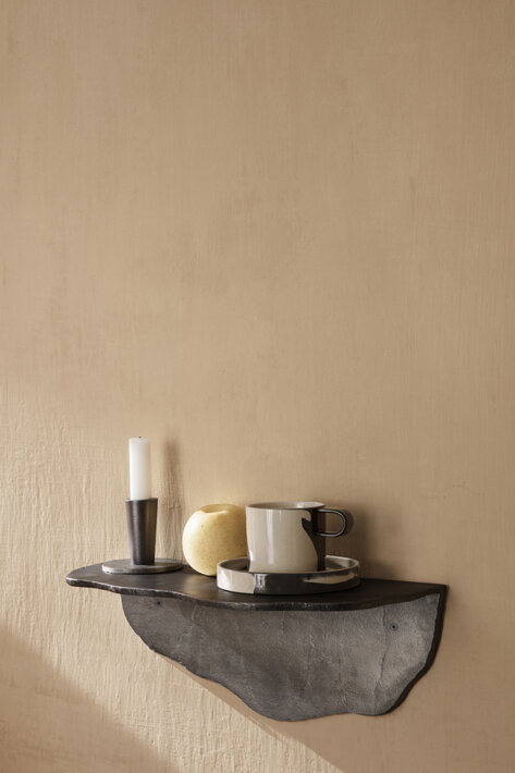 Dizajnová šálka s veľkým tanierikom na kamennej poličke v kuchyni