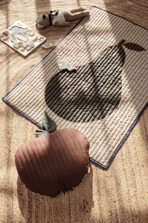 Detský prešívaný vankúš v tvare jablka na jutovom koberci s hračkami a prešívanou podložkou