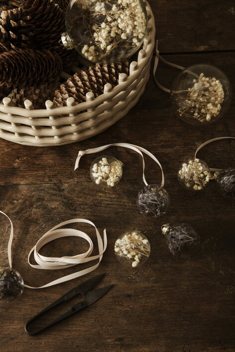 Vianočné gule zo skla s bielymi sušenými kvetmi v keramickom pletenom košíku