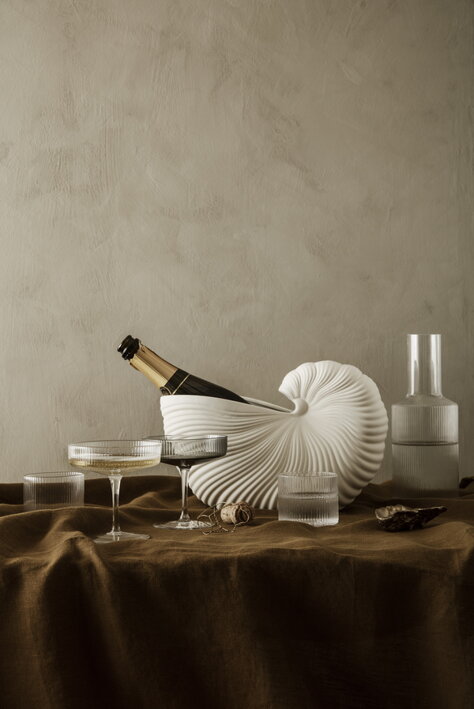 Nízke ručne fúkané poháre na slávnostnom stole so šampanským a dizajnovou karafou na vodu