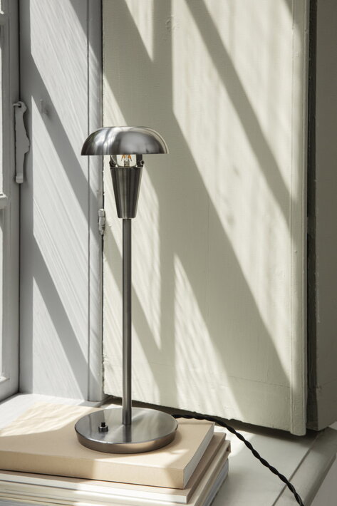 Elegantná strieborná stolová lampa s praktickým otočným tienidlom na parapete