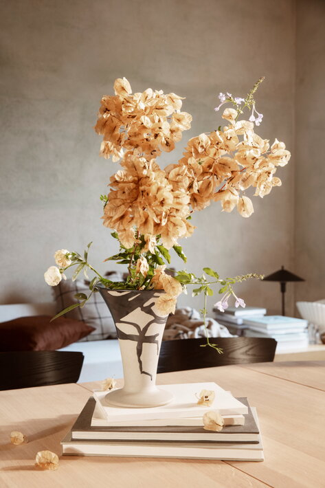 Ručne zdobená porcelánová váza s kyticou na jedálenskom stole