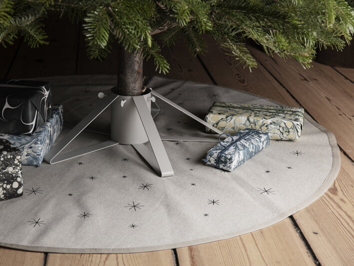 Sivý kovový stojan na vianočný stromček na okrúhlej bavlnenej podložke