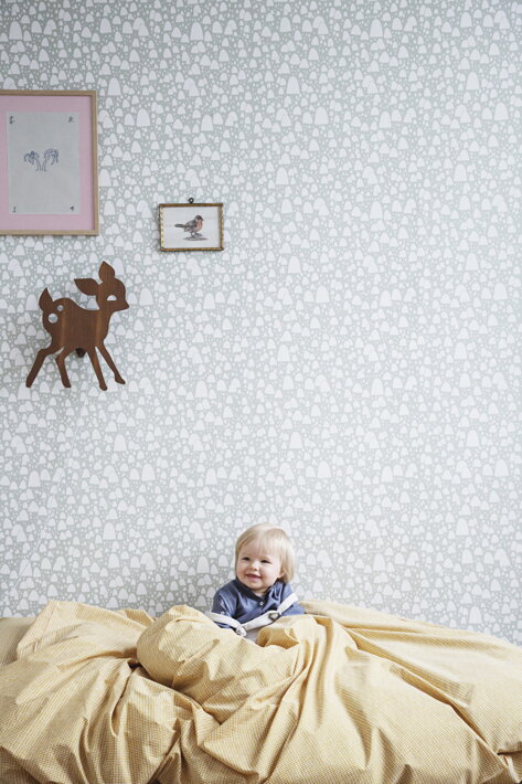 Lampa jelenček z dymovej dubovej dyhy na stene pri obrazoch nad bábätkom v posteli