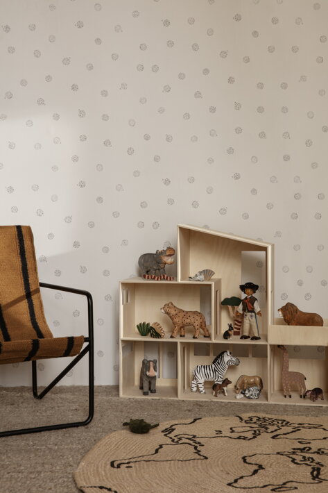 Hračkársky domček s drevenými figúrkami zvieratiek pri dizajnovom kresle