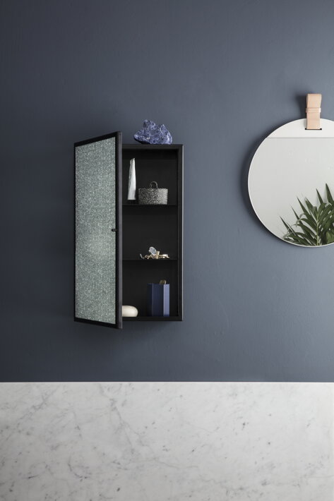 Dizajnová čierna skrinka s drôteným sklom na stene v predsieni pri štýlovom zrkadle