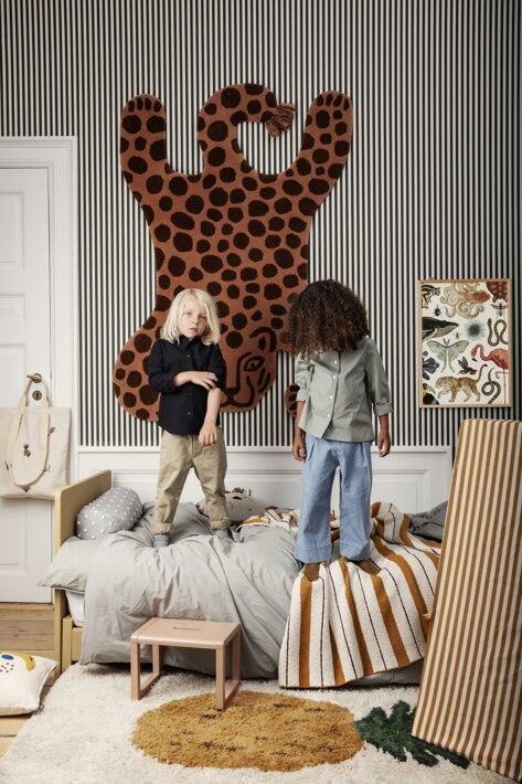 Drevený hračkársky stan s pruhovanou textíliou na koberci v štýlovej detskej izbe