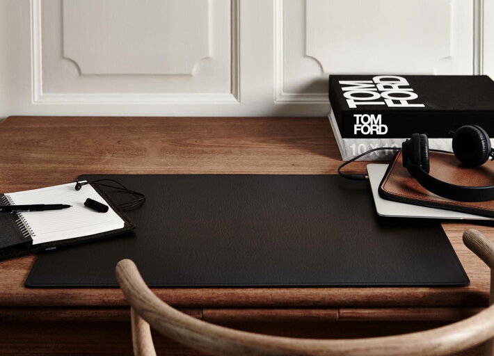 Čierna kožená podložka na drevenom stole v pracovni