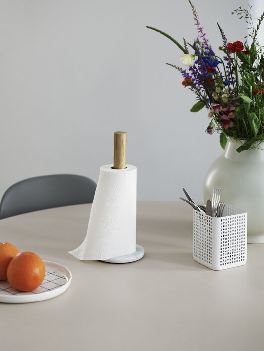 Drevený držiak na kuchynské utierky s bielym mramorovým podstavcom na stole s vázou