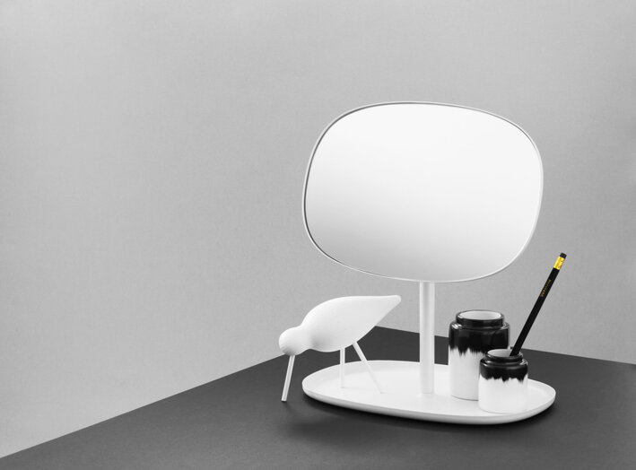 Biele stolové zrkadlo s úložným priestorom na čiernom stole s bielym dreveným vtáčikom