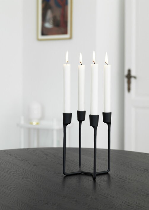 Dizajnový čierny svietnik z liatiny so štyrmi bielymi sviečkami